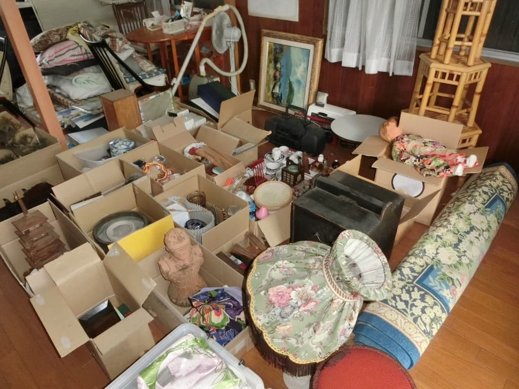 白い布で形見の品を丁寧に包む作業員の手元